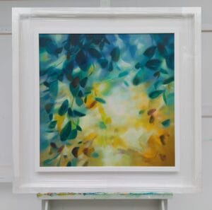 An original painting on canvas of a leafy canopy scene in mellow autumnal gold and green shades, in a bespoke off white frame.