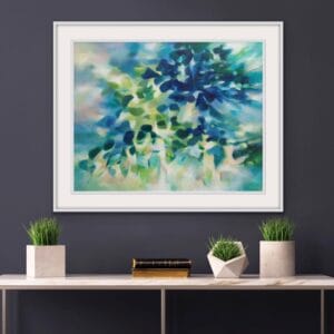An original painting on canvas in Soft Green and Blue colours with pops of yellow, of a leafy tree canopy with a Spring like feel in a bespoke with frame. set against a dark grey wall over a white marble and gold console table.