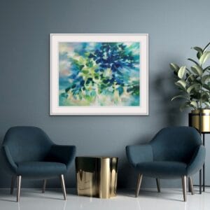 An original painting on canvas in Soft Green and Blue colours with pops of yellow, of a leafy tree canopy with a Spring like feel in a bespoke with frame. set against a dark teal wall with two velvet teal armchairs and a gold side table.