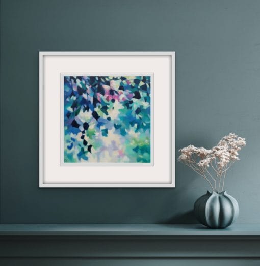 An original painting on canvas of leafy trailing plants in cool blue and green shades, with a pop of fuchsia pink, in a bespoke off white frame, set against a dark wall with a shelf and pot of dried flowers.