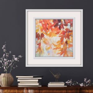 An original painting on canvas of a leafy canopy scene in mellow autumnal orange, gold and brown shades, in a bespoke off white frame. Set against a dark wall over a sideboard with a vase of flowers and books.